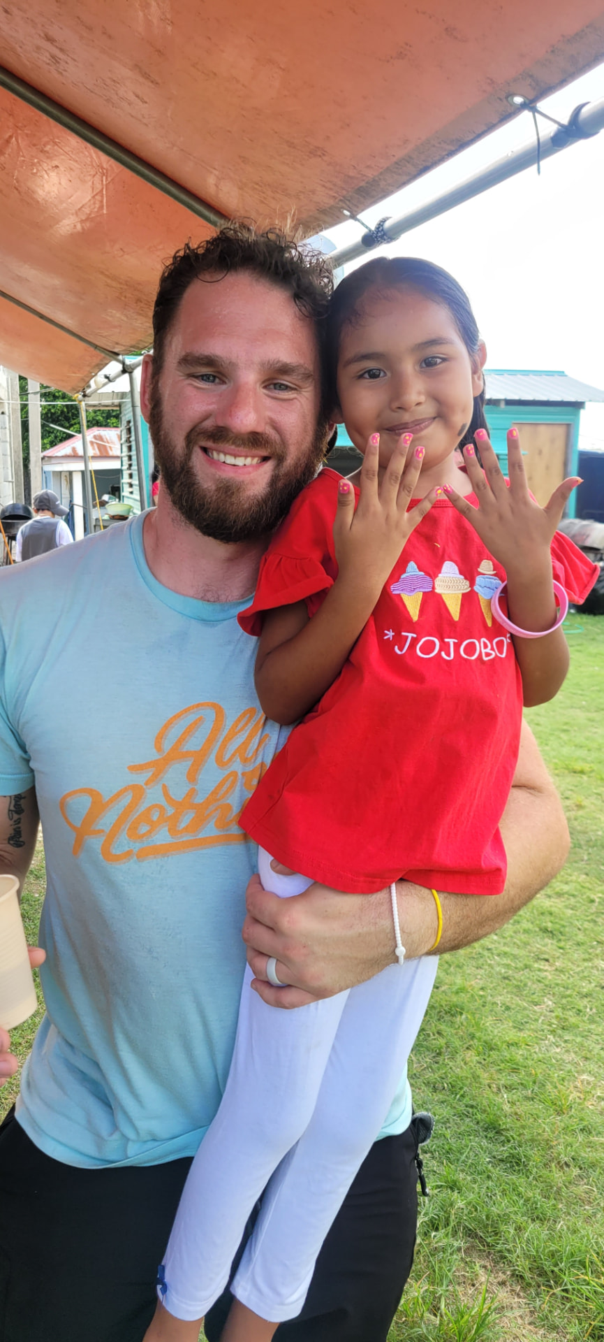Richard holding a young girl during the Belize mission trip